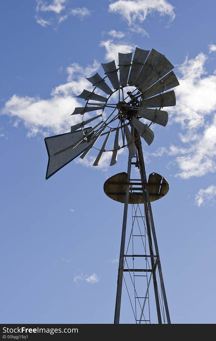 Windmill against clouds in sky