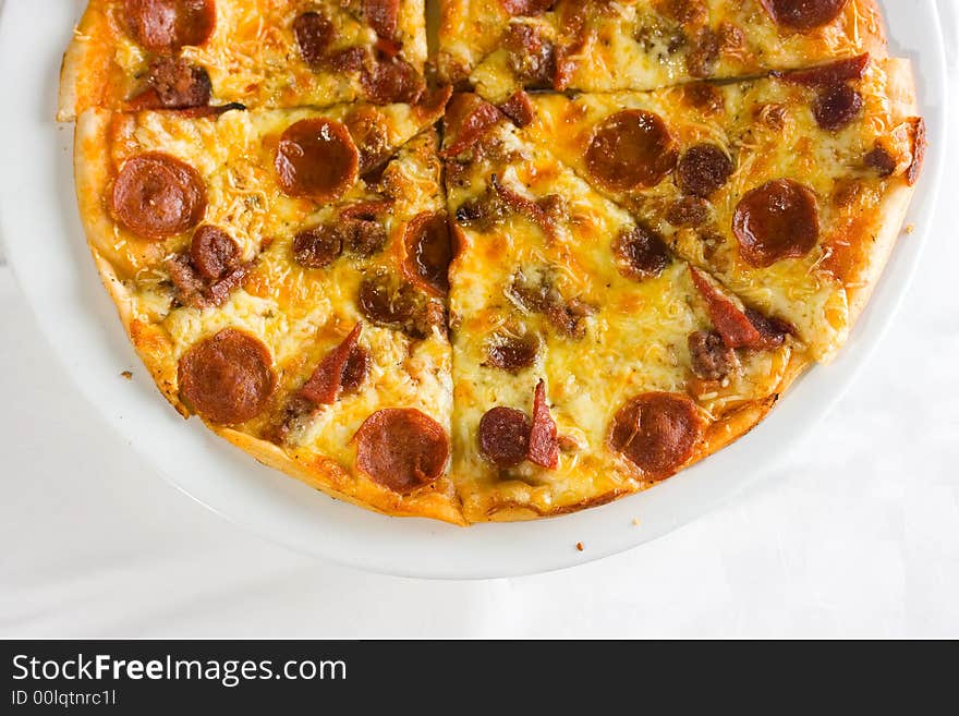 Detail shot of hot fresh pepperoni pizza isolated against a white background with great colors and depth of field. Room for text. Detail shot of hot fresh pepperoni pizza isolated against a white background with great colors and depth of field. Room for text.