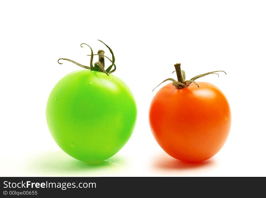 Close up of a red and a green round tomato on white background. Close up of a red and a green round tomato on white background