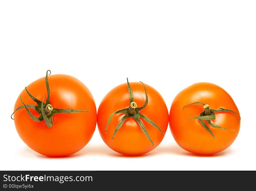 Three top viewed red round tomatoes lying on the same plane on white background. Three top viewed red round tomatoes lying on the same plane on white background