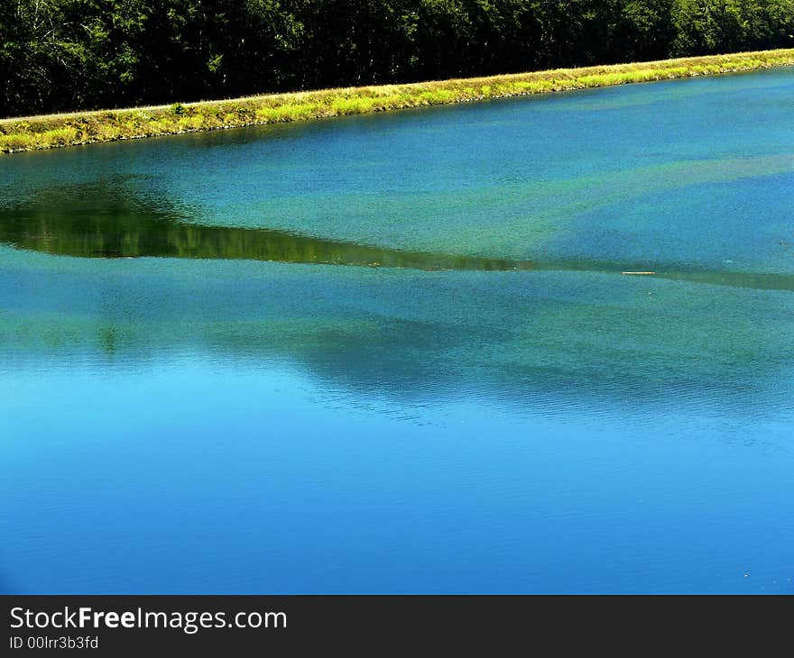 A shot of a lake with a green shore. A shot of a lake with a green shore.