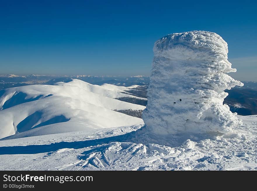 There are winter Mountains with triangulation mark on foreground.