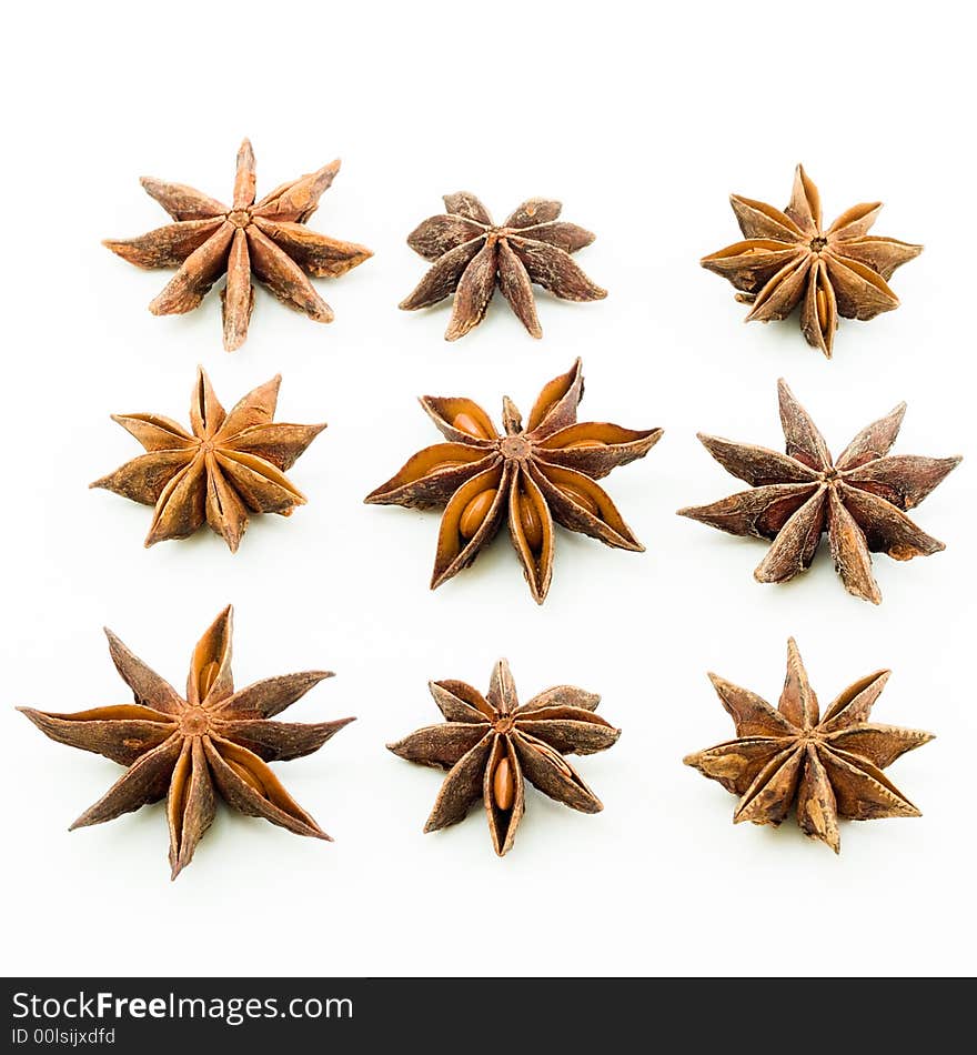 Arrangement of nine star anise in three rows with each star showing the bottom view. Arrangement of nine star anise in three rows with each star showing the bottom view