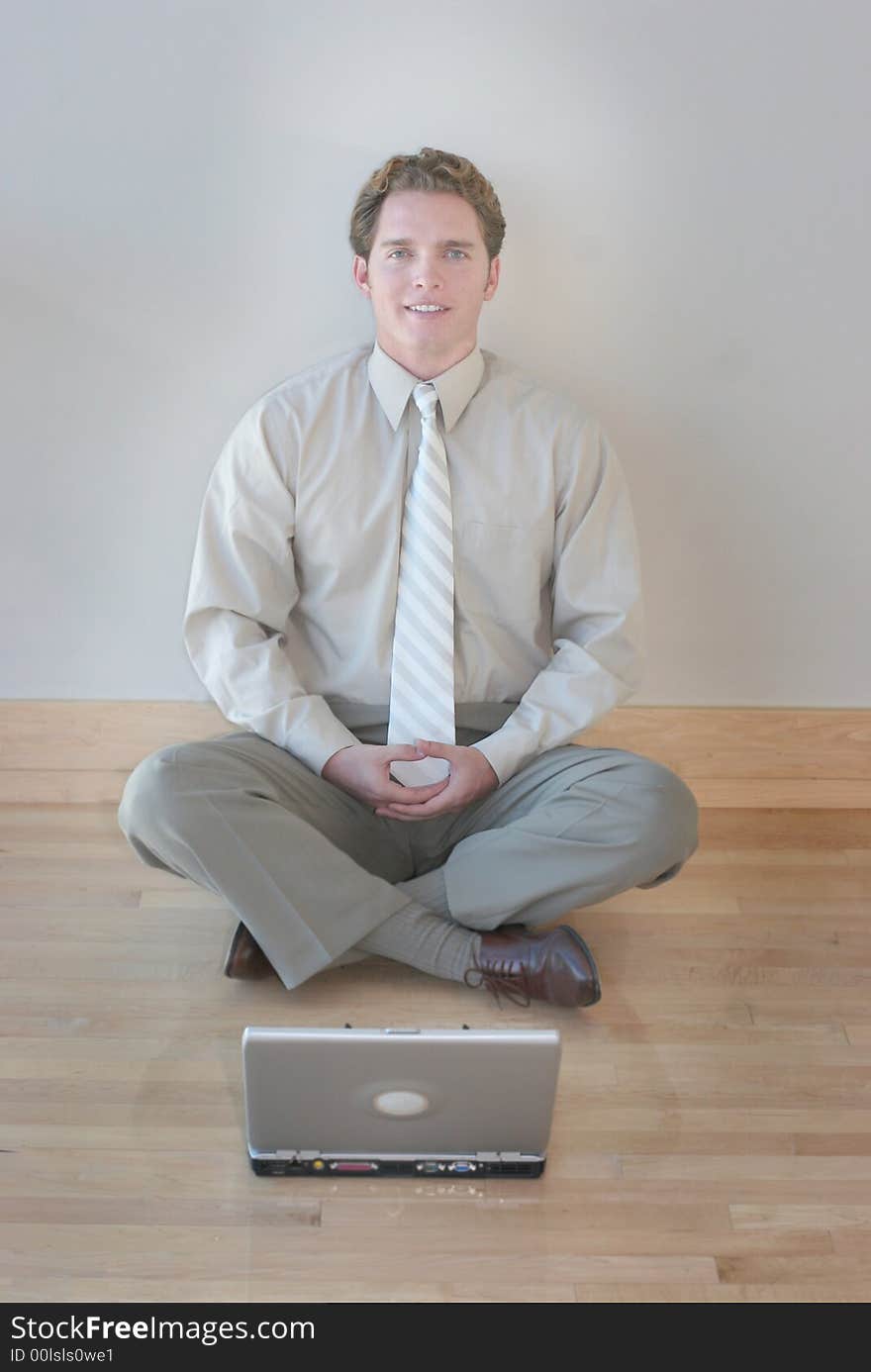 One businessman sitting with hands touching next to laptop smiling. One businessman sitting with hands touching next to laptop smiling