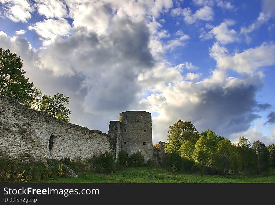 Medieval castle and green trees under blue sky with clouds. Medieval castle and green trees under blue sky with clouds