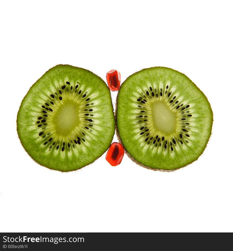 Two kiwis and pomegranate on a white background