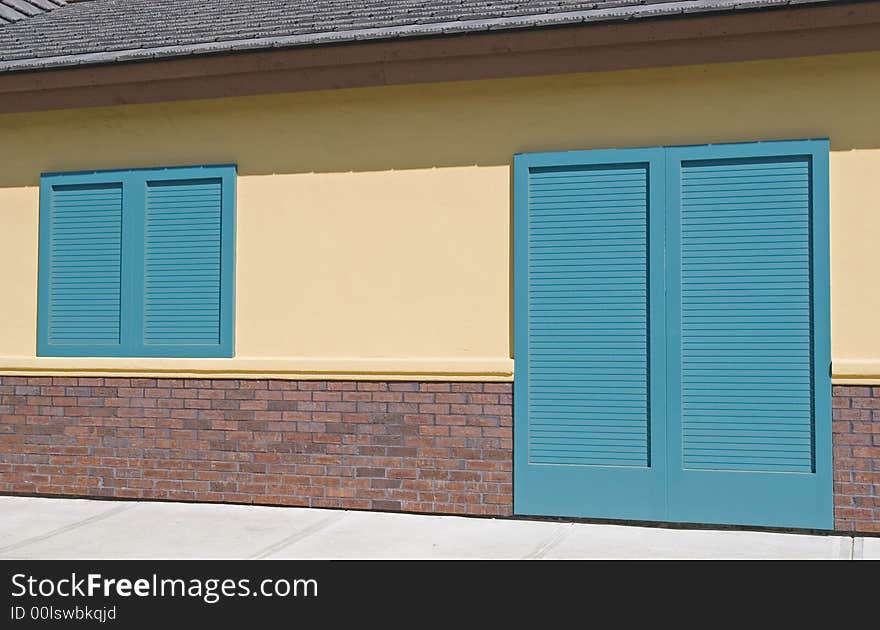 Bright green shutters on a pink stucco and brick building. Bright green shutters on a pink stucco and brick building