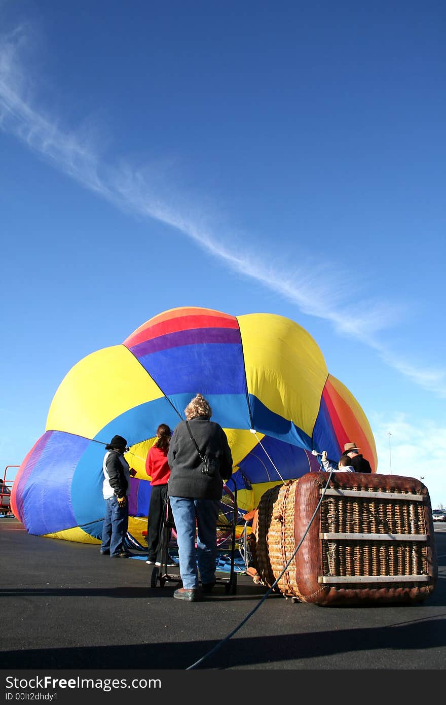 The Hot Air Balloon crew has found a suitable launch area and they begin to blow in air with the burner system and a large fan. The basket, now on it's side, will set upright when the balloon envelope is full. The Hot Air Balloon crew has found a suitable launch area and they begin to blow in air with the burner system and a large fan. The basket, now on it's side, will set upright when the balloon envelope is full.