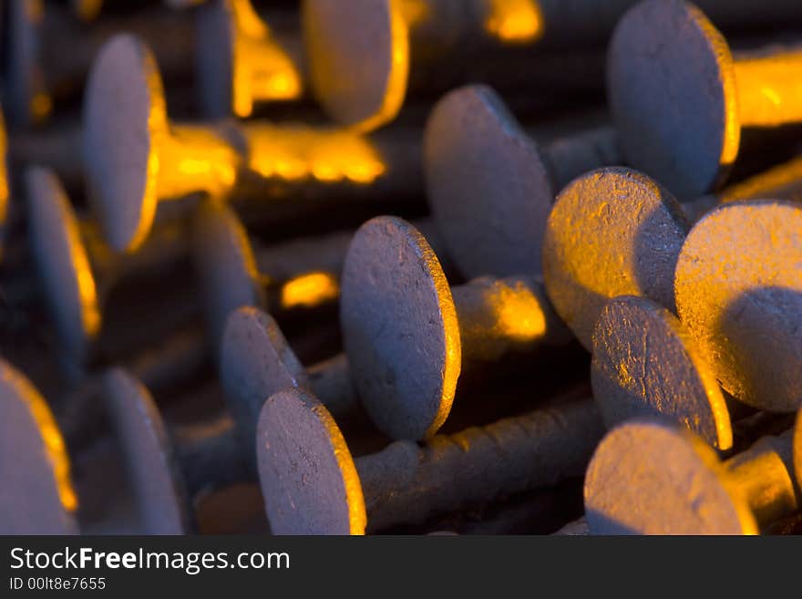 A stack of old nails under colored lights.