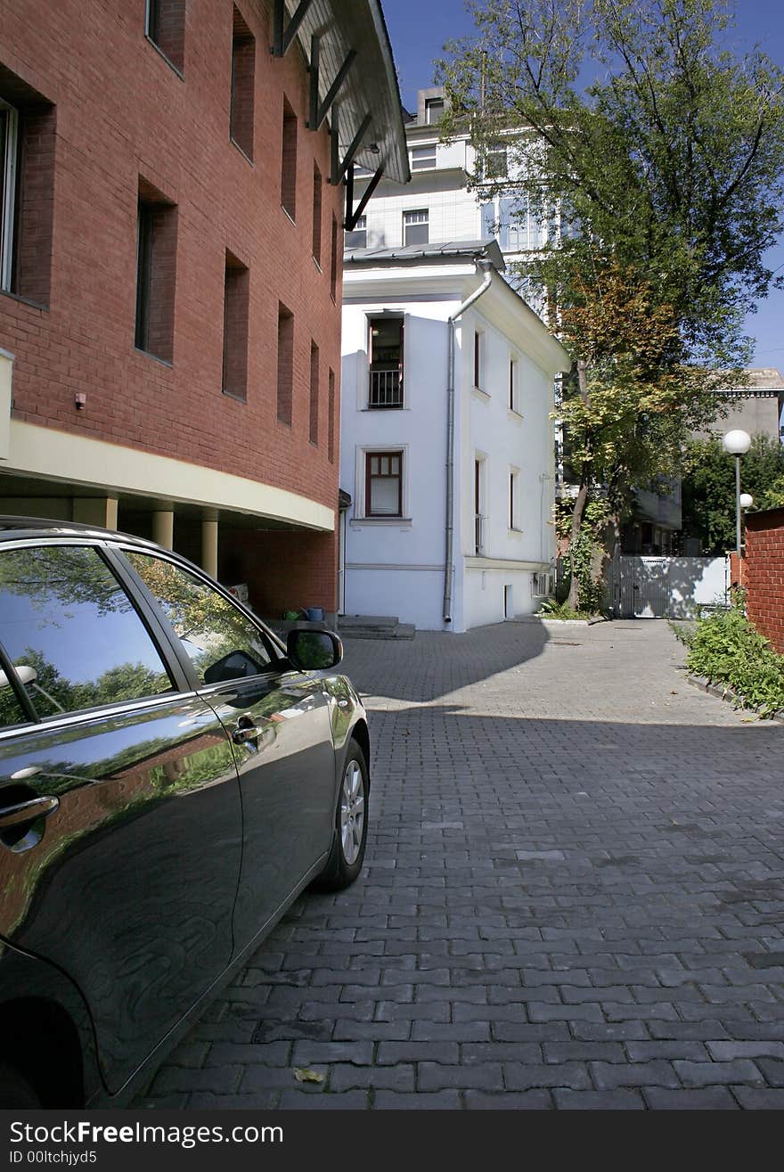 Internal courtyard vein building with car on a paving stone. Internal courtyard vein building with car on a paving stone