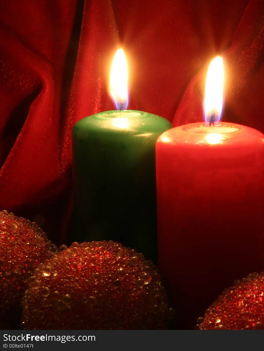 Two Candles, red and green and Christmas tree decorations