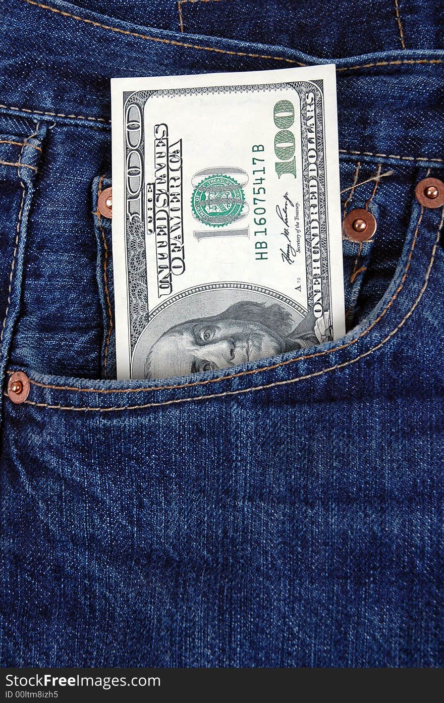 A one hundred dollar bill in the pocket of denim trousers.  Photographed in a studio. A one hundred dollar bill in the pocket of denim trousers.  Photographed in a studio.