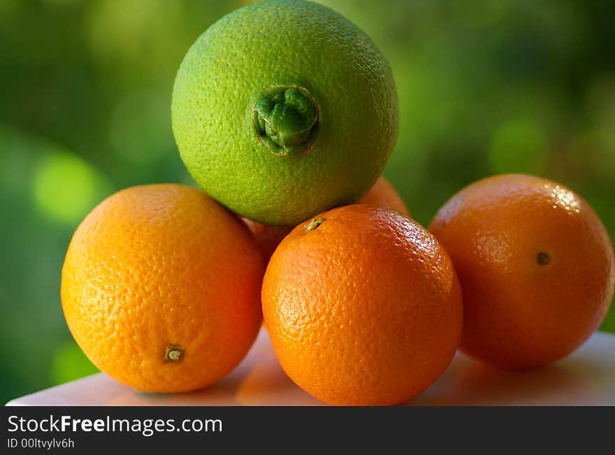 A green orange and other mature oranges.