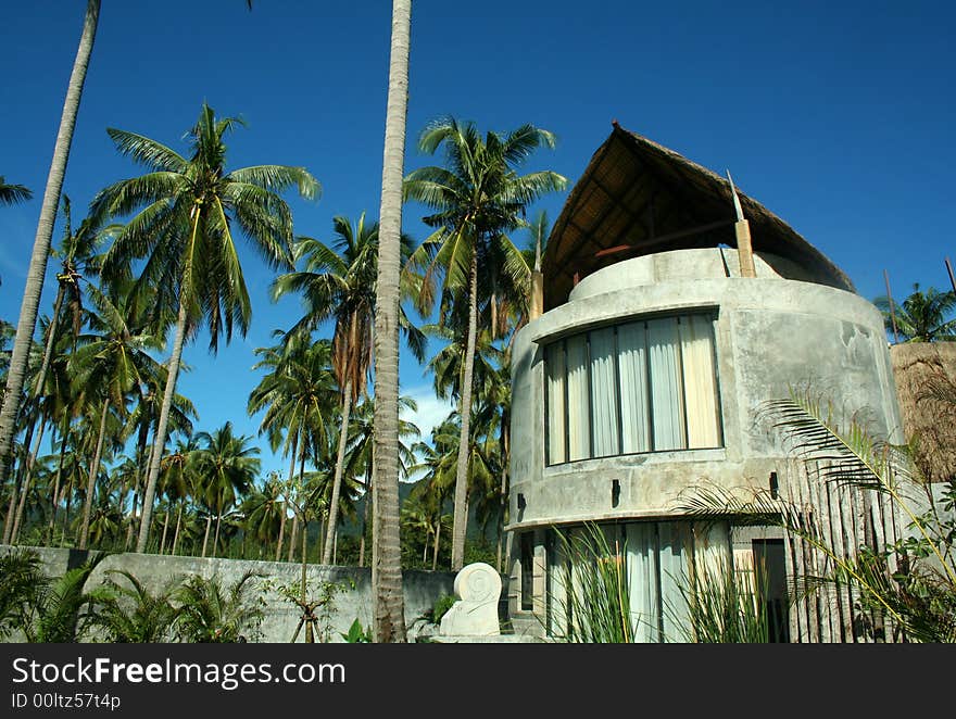 Modern house near tropical beach with palm trees and blues sky background. Modern house near tropical beach with palm trees and blues sky background.