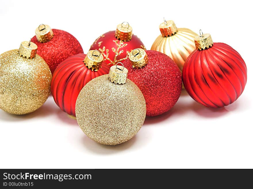 A grouping of red and gold Christmas ornaments.  Focus on front ornament. A grouping of red and gold Christmas ornaments.  Focus on front ornament.