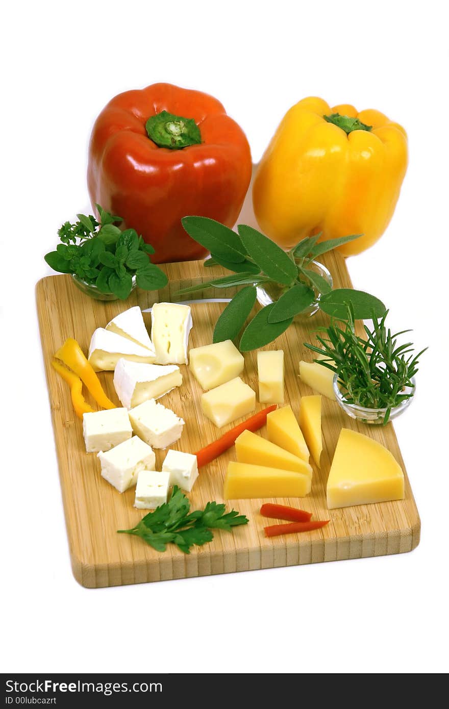 Bamboo cheese board with camembert, feta, ementaler, green herbs and peppers. Bamboo cheese board with camembert, feta, ementaler, green herbs and peppers.