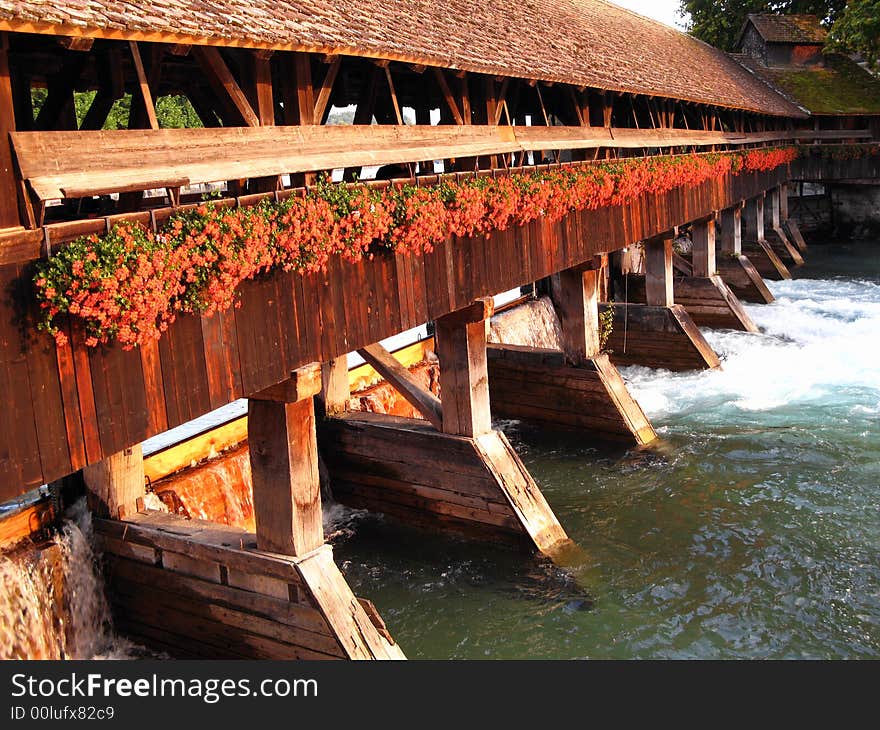 A swiss traditional design wooden bridge over Aare river in the city of Thun in sunset light. A swiss traditional design wooden bridge over Aare river in the city of Thun in sunset light.