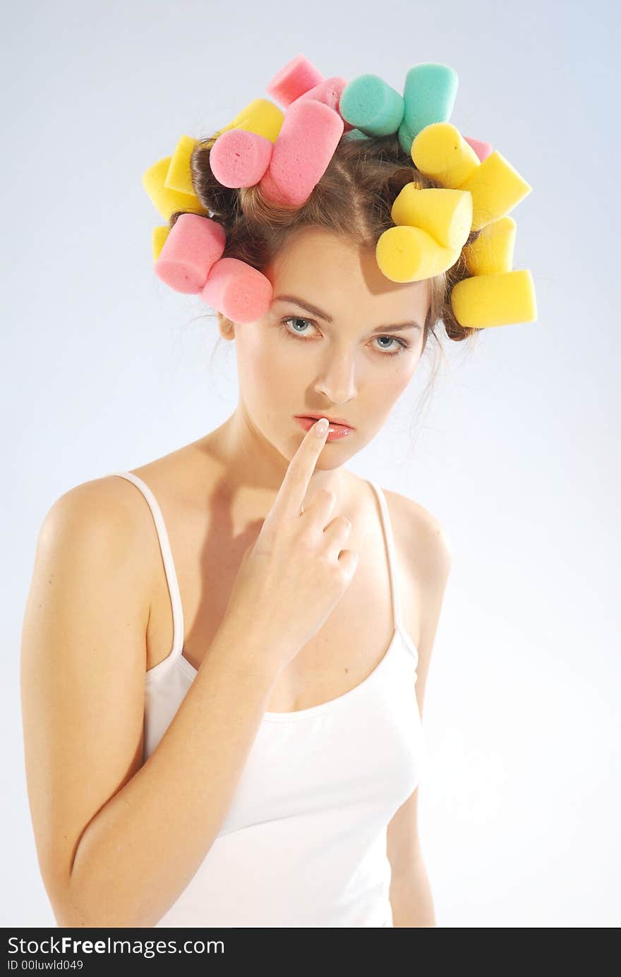 An young woman with curlers on her head. An young woman with curlers on her head