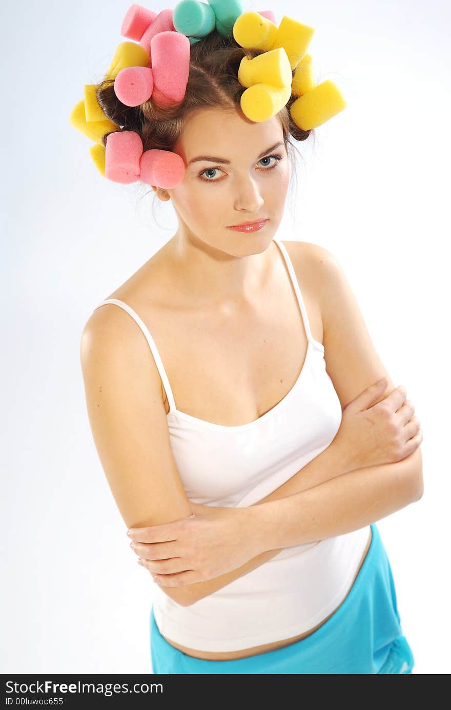 An young woman with curlers on her head. An young woman with curlers on her head