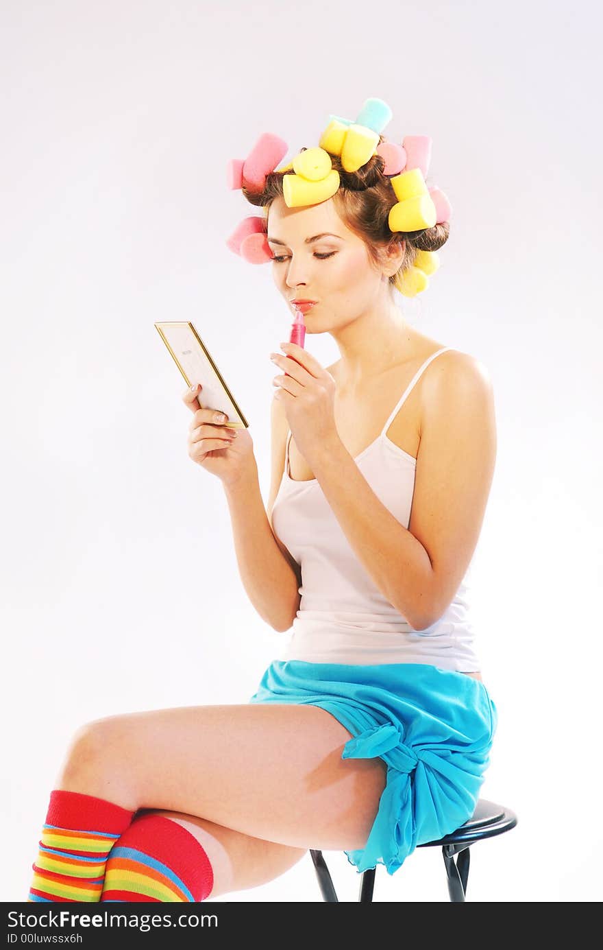 An young woman with curlers and lipstick. An young woman with curlers and lipstick