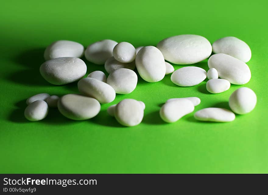 White stones of quartz on a green surface