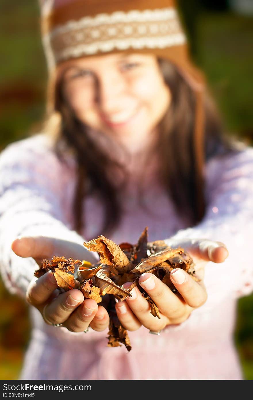 Beautiful Autumn - beautiful young girl holding golden leaves in her hands - focus on them