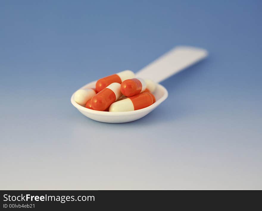 The batcher to medicines together with capsules on the blue background