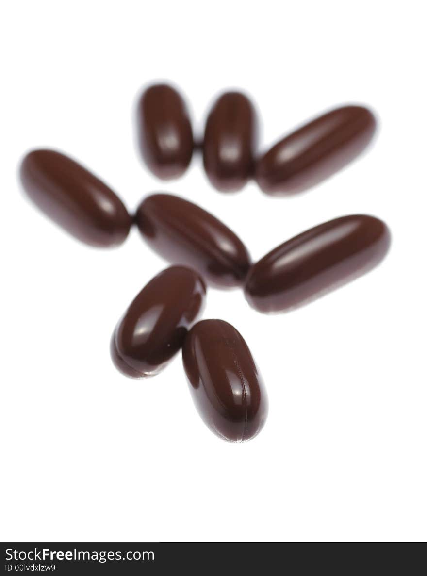 Brown Pills On White Background, Close-Up Shot, Focus On Front