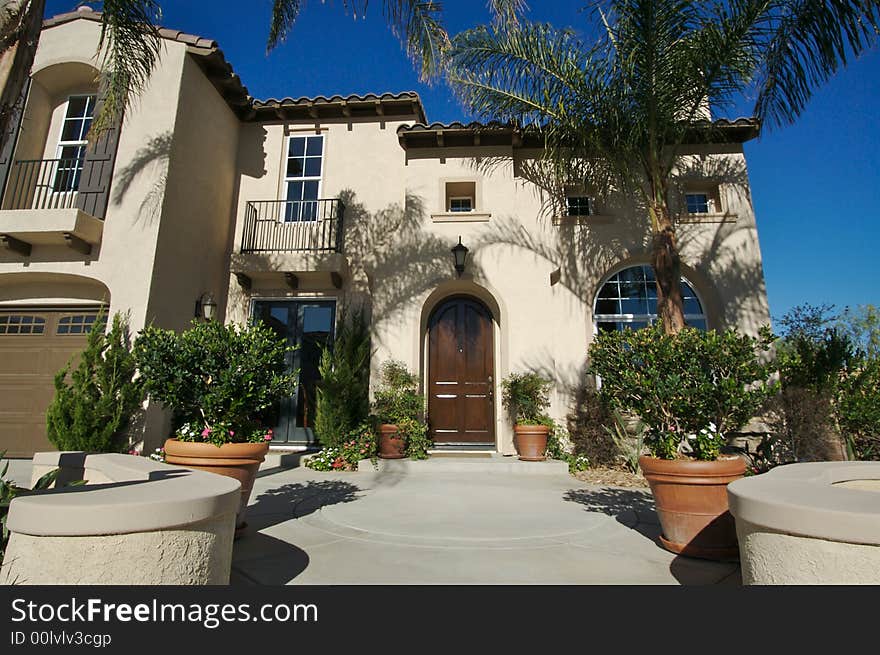 A newly constructed, modern american home with fresh landscaping & palm trees. A newly constructed, modern american home with fresh landscaping & palm trees.