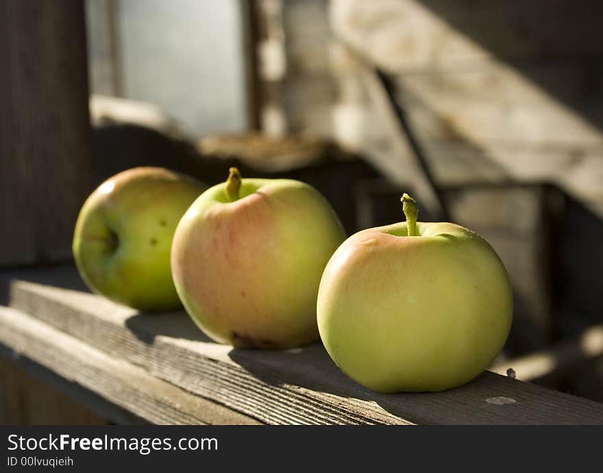 Three apples lies on the window