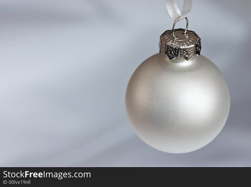 Silver christmas bauble on a silver/white background. Silver christmas bauble on a silver/white background