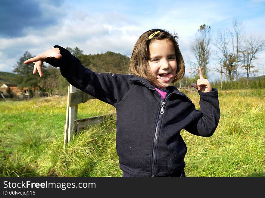 Little girl being silly on grass field. Little girl being silly on grass field