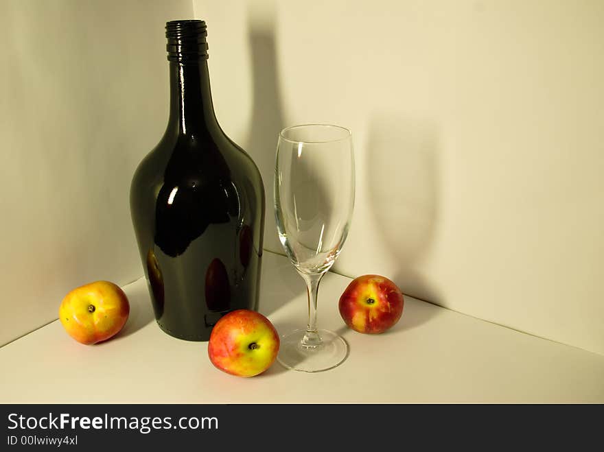 Of Picture depicting a black bottle, empty glass, nectarine with shadows reflecting on white background in fruit-piece style.