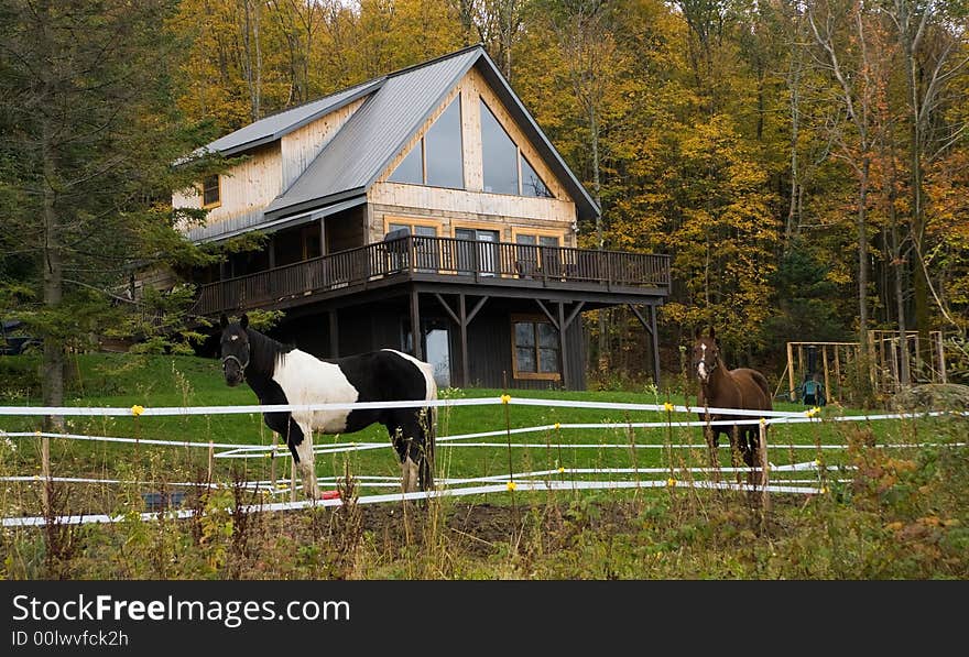 Gorgeous mountain cottage with two horses in the foreground. Gorgeous mountain cottage with two horses in the foreground