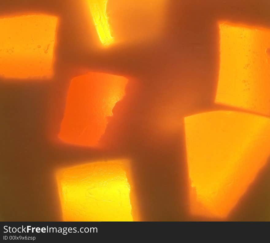 Full frame photograph of yellow and orange handmade glycerin soap with a light shining through it giving it an abstract glow. Full frame photograph of yellow and orange handmade glycerin soap with a light shining through it giving it an abstract glow.