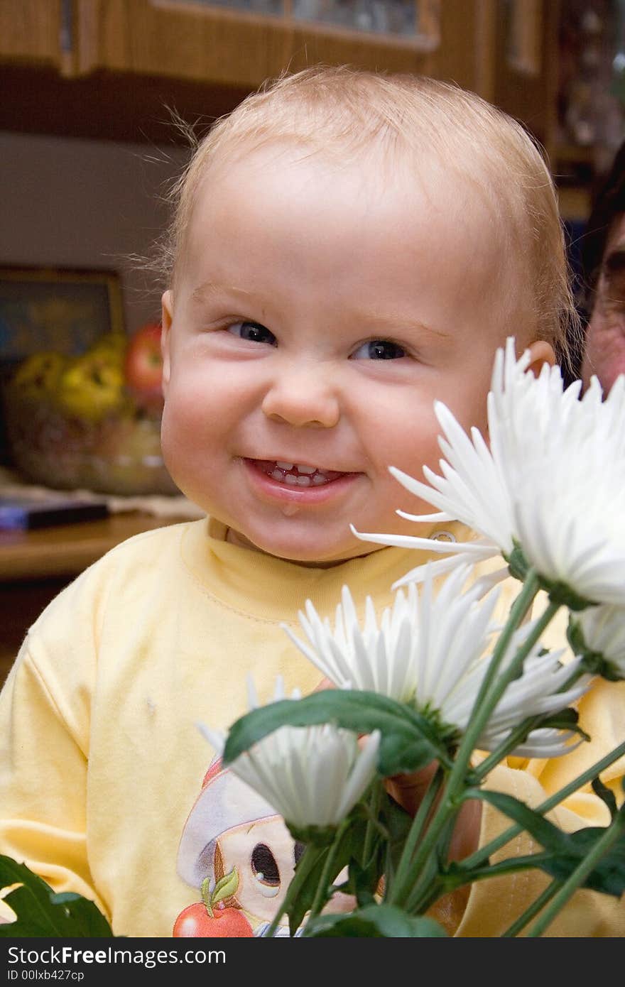 Smiling baby in the room with flowers. Smiling baby in the room with flowers