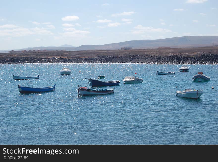 Lagoon on lava island Fuerteventura, Canaries, where small fishing boats are anchoring. Lagoon on lava island Fuerteventura, Canaries, where small fishing boats are anchoring.