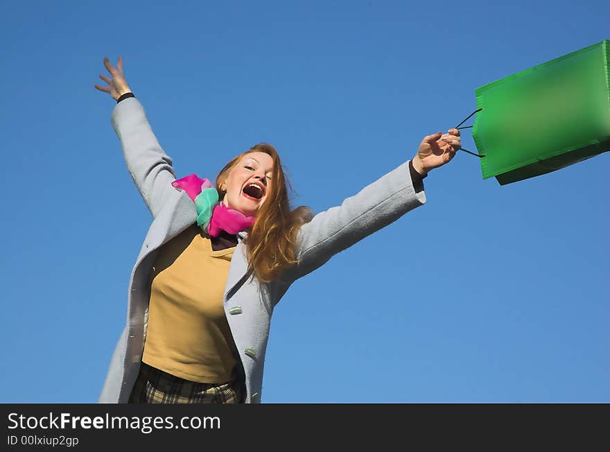 The woman with purchases on a background of the sky