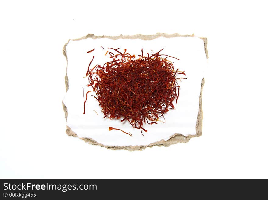 Saffron on pieces of paper with torn edges, isolated on white