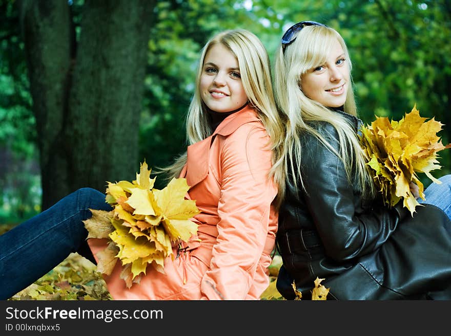 Cute girls sitting on leaves. Cute girls sitting on leaves.