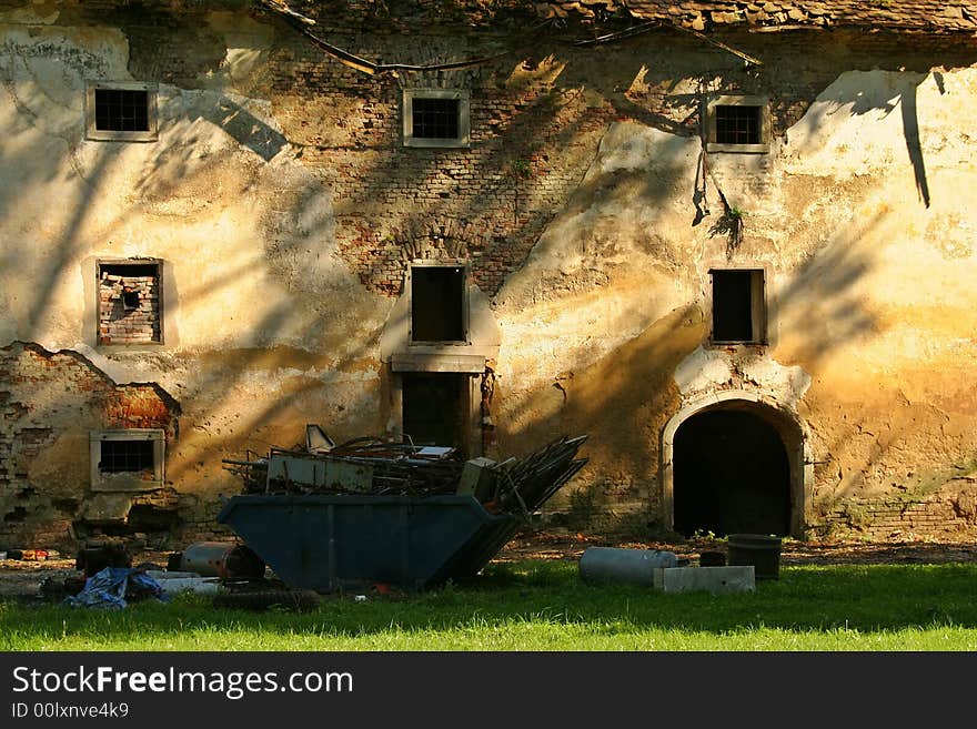 Old ruined building with dumpster and garbage