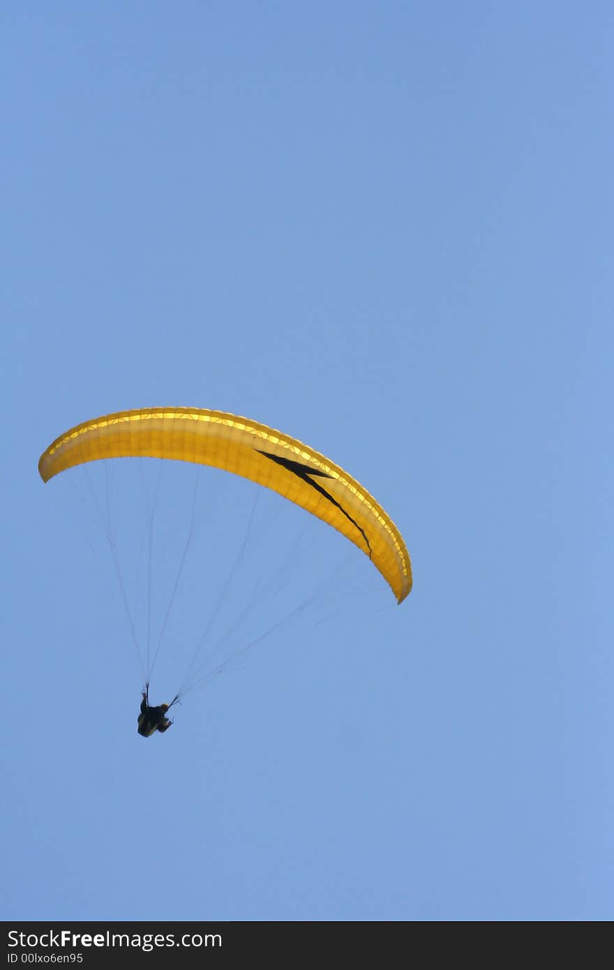 Yellow paraglider on the sky