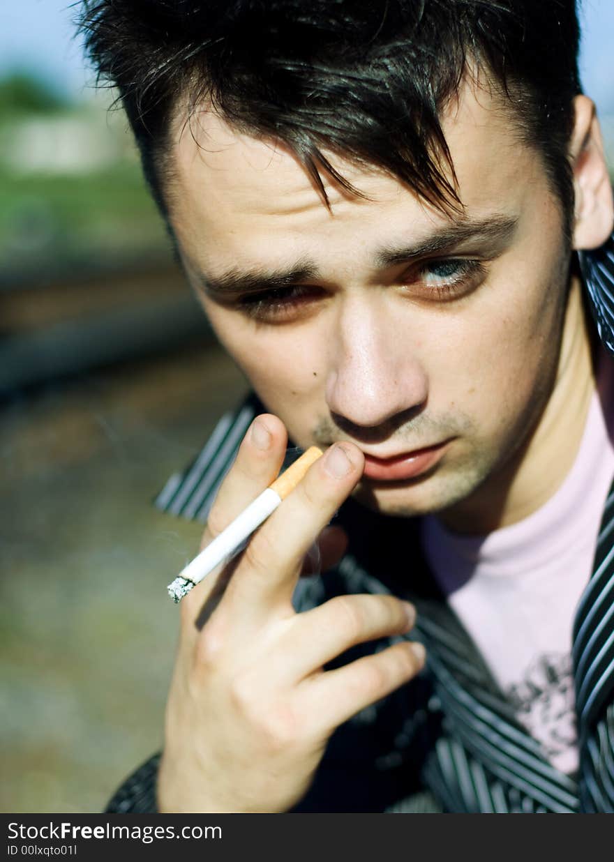 Young male smoking cigarette. Close up shot.