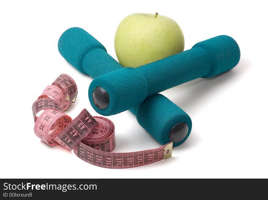 Dumbells, apple and measuring tape on a white background