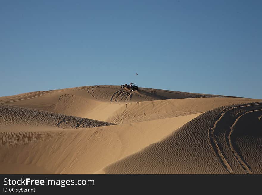 Beautiful sand dunes in Glamis California, with vehicle tracks and a sand rail at the top