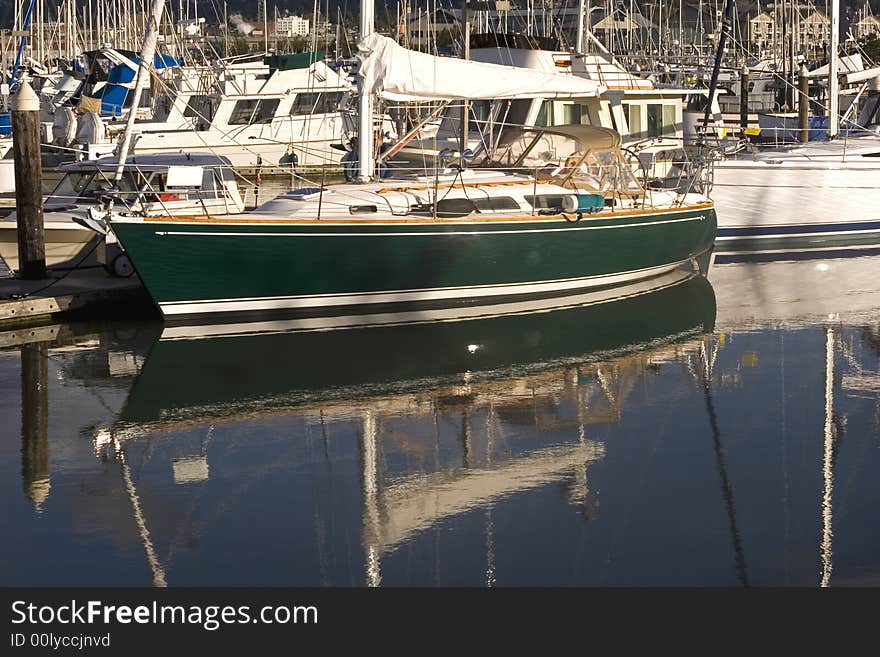 A nice green boat tied up at a marina