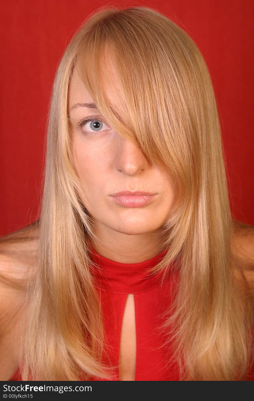 Blonde girl in red dress over red background