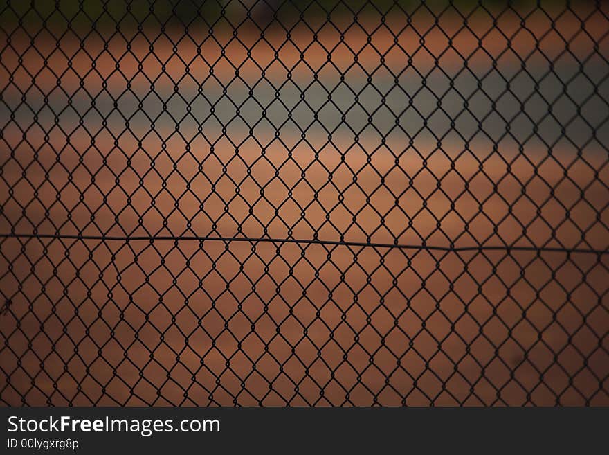 Tennis court fence, focus on the fence and court blurred