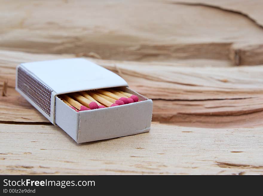 An open box of matches on a log.