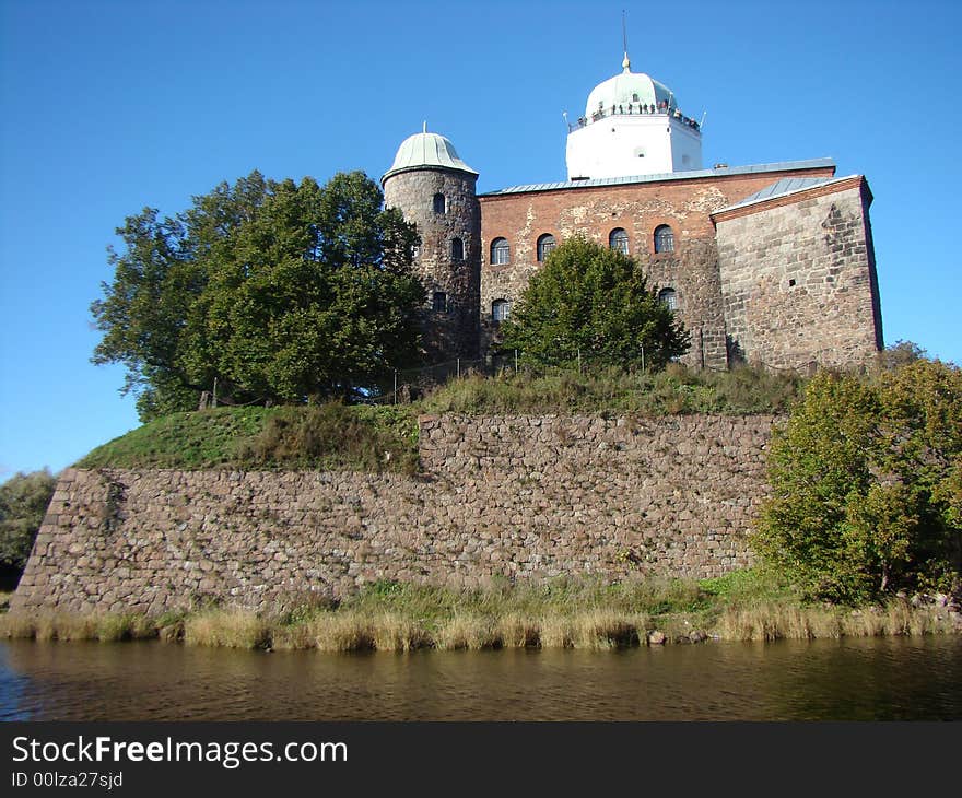 Old fortress in Russia. A protective stone wall. The fortress is surrounded by water. A monument of architecture